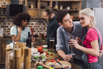 men hugging girl during party in kitchen