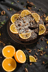 Obraz na płótnie Canvas Beautiful and tasty chocolate cake with orange and nut on a dark background