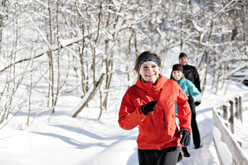 Group of friends enjoying jogging in the snow in winter