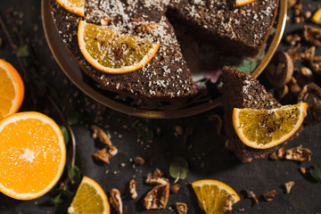 Beautiful and tasty chocolate cake with orange and nut on a dark background