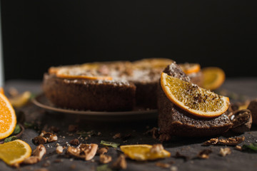 Beautiful and tasty chocolate cake with orange and nut on a dark background