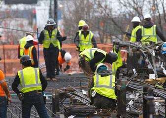Workers on construction site - men in green green reflective vests