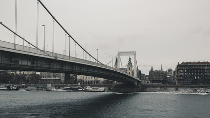 View of the bridge over the Danube river in Budapest, in the background old vintage house. Photo in retro style
