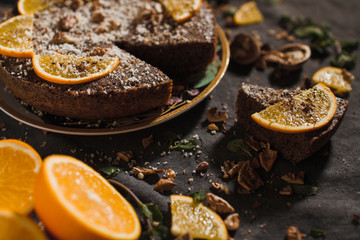 Beautiful and tasty chocolate cake with orange and nut on a dark background
