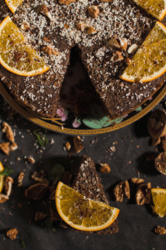 Beautiful and tasty chocolate cake with orange and nut on a dark background