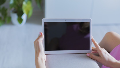 Woman at home relaxing reading on the tablet computer 