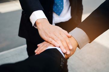close up group of three business man team joining hands together in the modern city, team leader,...