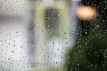 Raindrops on a window pane with out-of-focus background