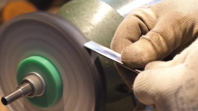 Sharpening a chisel on grinding machine