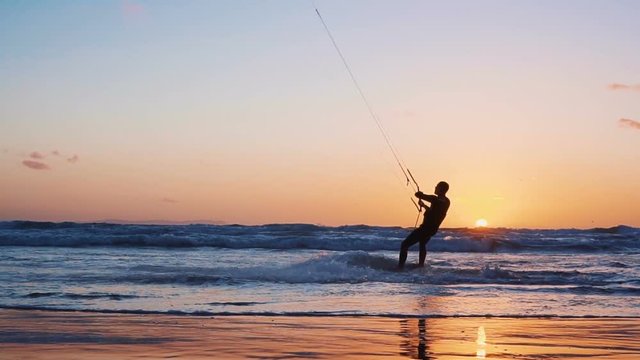 The kite-surfing surfer sails on the ocean wave. Maldives. Slow motion