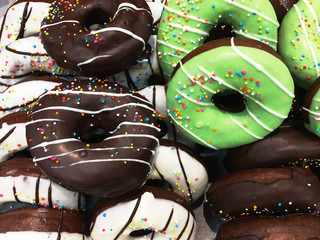 Multicolored donuts close-up on a wooden background. Delicious dessert