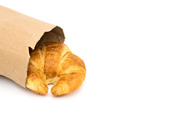 croissant in brown paper bag.