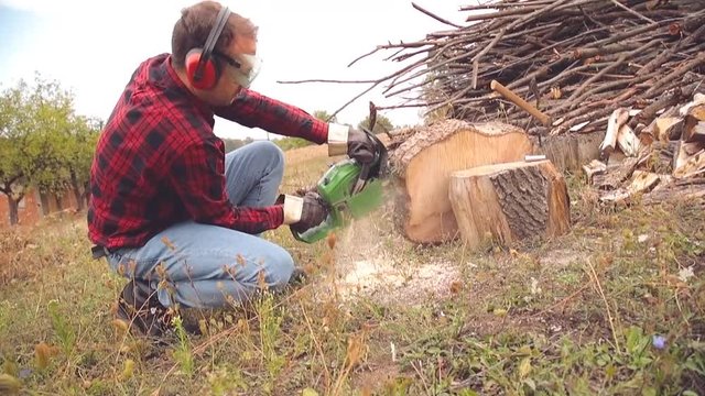 Lumberjack cutting woods with a chainsaw for winter.