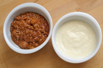How to cook Italian lasagna,two bowls with meat sauce and bechamel sauce, ready to fill a tasty lasagna