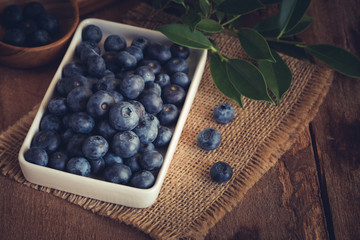 Blueberry in a white bowl on wood table