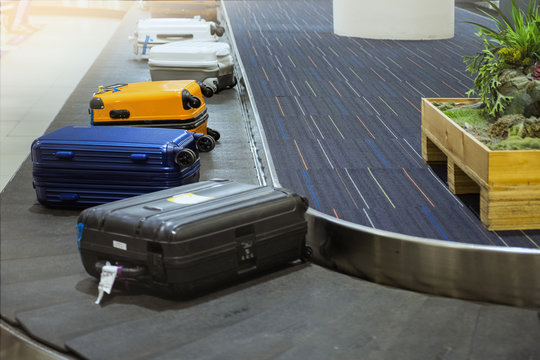 suit case on luggage conveyor belt at baggage claim in airport terminal.