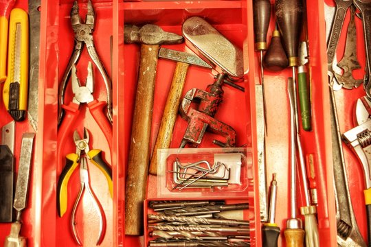 Tools in red metal toolbox, background