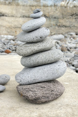 Fototapeta na wymiar Stone cairn tower, poise stones, rock zen sculpture, light grey pebbles