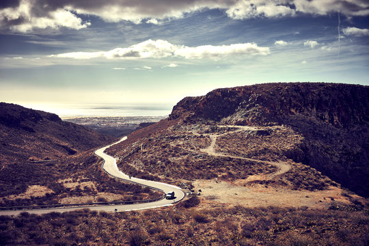 Dusty road to horizon of wide stone desert / Barren south of Island of Gran Canaria in Spain
