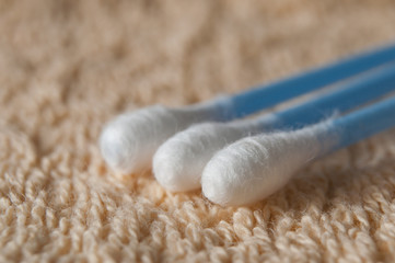 Fototapeta na wymiar coton-tige bleu sur fond de serviette de toilette