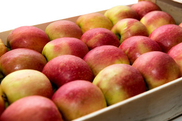 wooden crate with  red and yellow apples, on white background