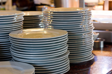 A stack of white porcelain big plates in a restaurant