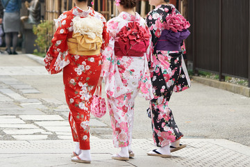 Fototapeta na wymiar Young girl wearing Japanese kimono standing in front of Sensoji Temple in Tokyo, Japan. Kimono is a Japanese traditional garment. The word 