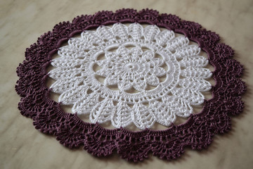 White and purple hand hooked coaster. Knitted holders for hot work