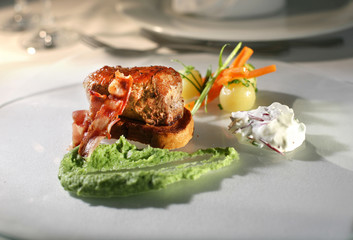 Veal fillet with broccoli and cumin cream covered with fried bacon