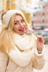 Fototapeta premium Closeup portrait of adorable young woman with natural makeup eating caramel candies