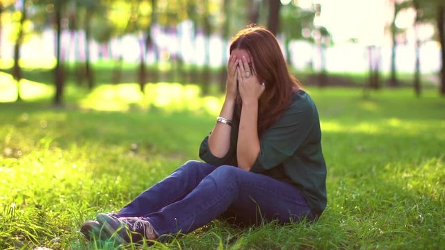 woman waiting a gift with a n eyes closed with two hands in the park Slow motion