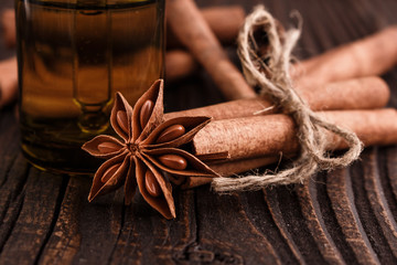 Cinnamon essential oil on a wooden background