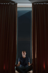 dark room, the boy is doing yoga