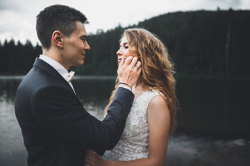 Beautiful gorgeous bride posing to groom and having fun, luxury ceremony at mountains with amazing view, space for text, wedding couple