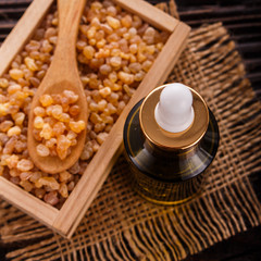 frankincense essential oil on a wooden background