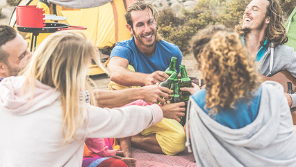 Group of happy friends cheering with beers in camping