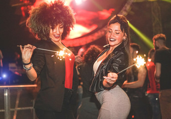 Young women making party with fireworks inside night club