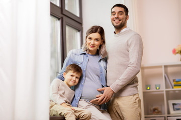 Obraz premium happy family with pregnant mother at home