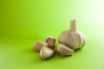 Alho e dentes de alho em fundo verde