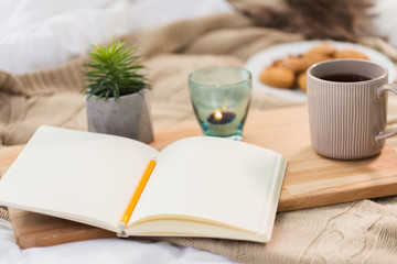 diary, tea and candle in holder at home