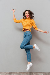 Full length image of Pleased brunette woman in sweater