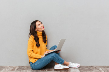 Side view of pensive happy woman sitting on the floor