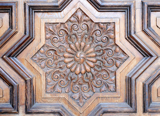 Eight-pointed star, closeup of a carved wooden door in a church of Seville, Spain