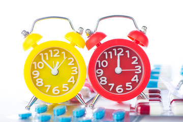 Alarm clock on medical blister pack show medicine time