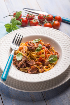 tagliolini with squid and fresh tomatoes, selective focus
