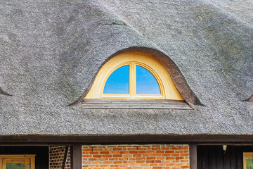 Ancient reed-covered roof with a window in it