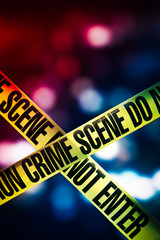 high contrast image of Crime scene tape with red and blue lights on the background