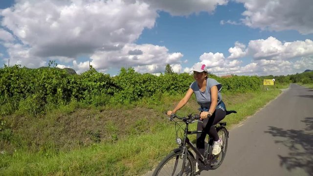 Pretty girl biking on Balaton bike trail near the Lake Balaton of Hungary
