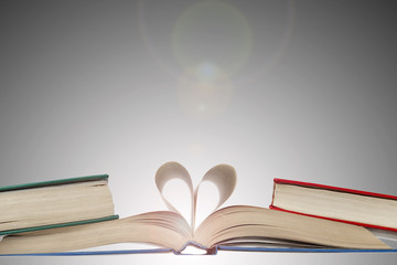 An open book with a heart from the pages, a love of reading and science.