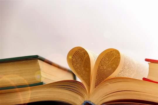 An open book with a heart from the pages, a love of reading and science.